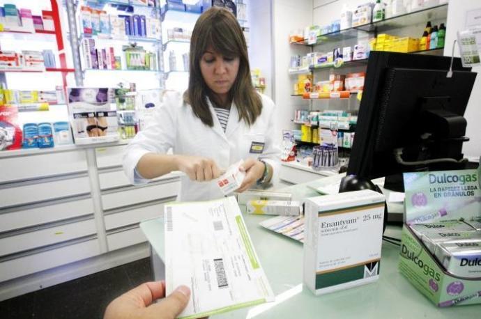 Una mujer despacha medicamentos en una farmacia.