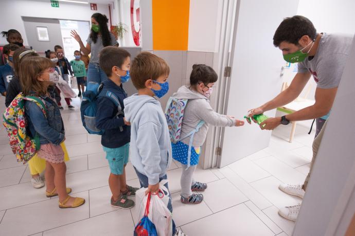 Un profesor echando gel en las manos de un alumno Foto: J.M.Martínez