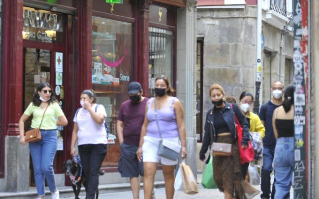 Varias personas paseando por la calle.