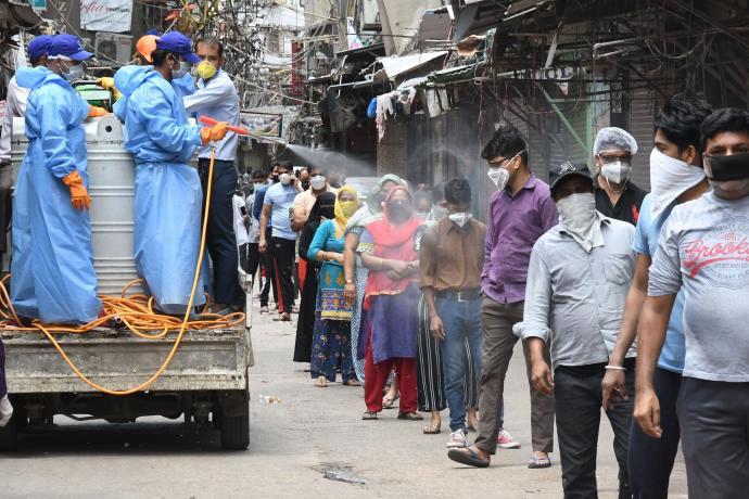 Desinfectan a ciudadanos antes de acceder a un centro en el que se realizan test de coronavirus en Nueva Delhi.