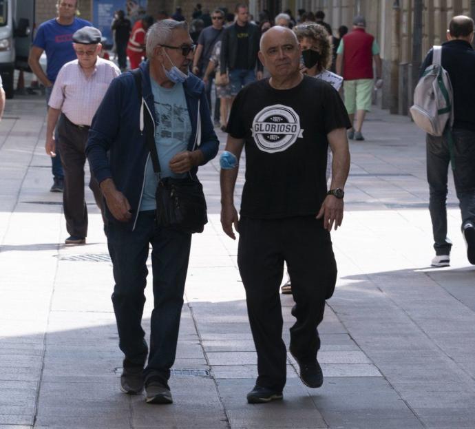 Dos personas ajenas a la información pasean por Vitoria.