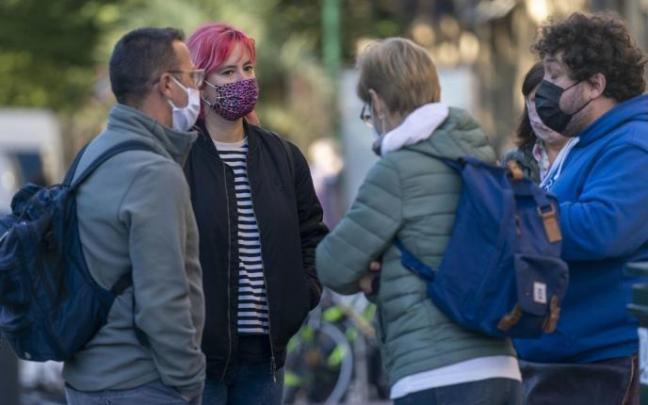 Varias personas conversan en la calle