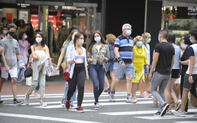 Varias personas paseando por la calle.
