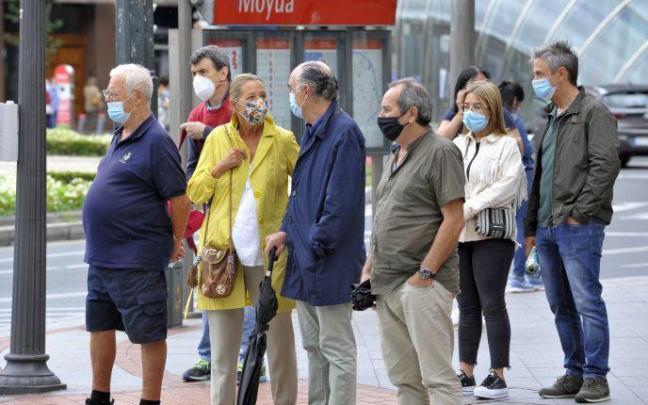 Un grupo de personas con mascarilla por la calle en Bilbao