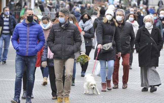 Gente paseando por la calle con mascarilla