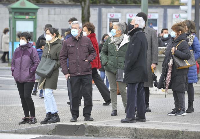 Personas en la calle llevando mascarilla