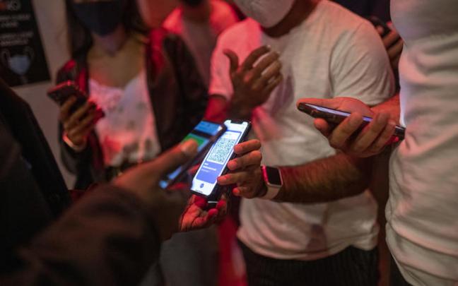 Jóvenes muestran el certificado covid para acceder a un local nocturno.