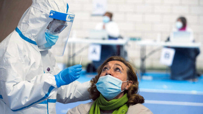 Un sanitario realiza una prueba PCR a una mujer