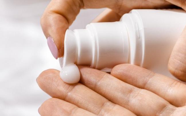 Una mujer se aplica crema solar. Una mujer se aplica crema solar.