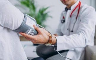 Un médico toma la tensión a un paciente Un médico toma la tensión a un paciente
