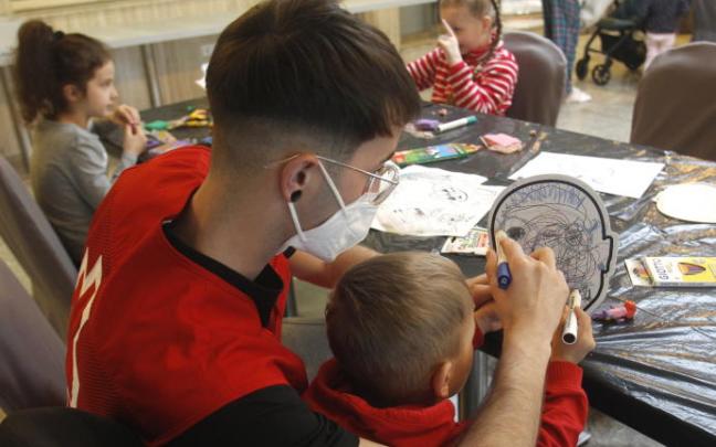Un voluntario de la Cruz Roja entretiene a varios niños ucranianos