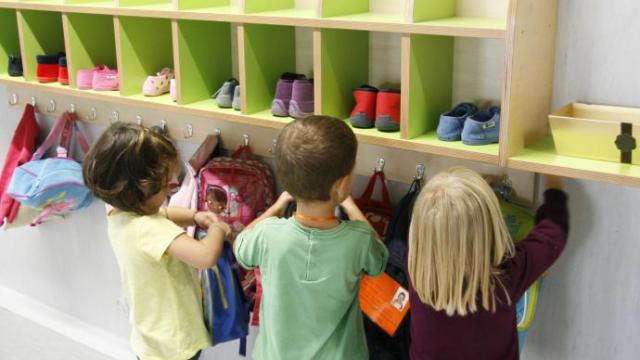 Tres niños se preparan antes de una clase en una ikastola.
