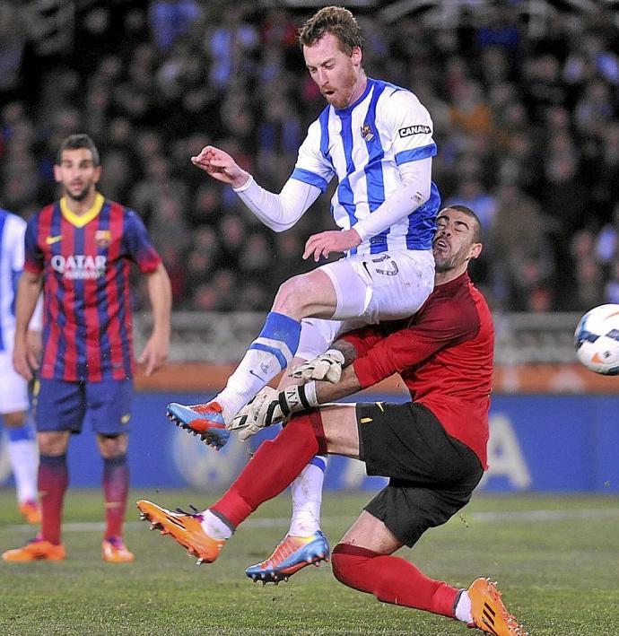 Zurutuza choca con Víctor Valdés tras rematar el balón para marcar en el 3-1 de la Liga 2013-14.