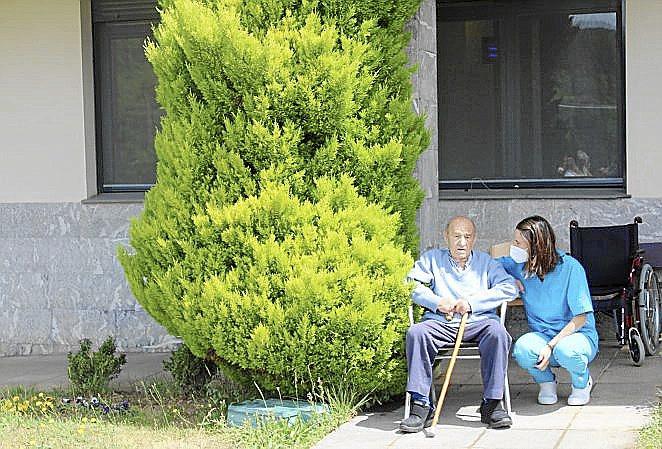 Félix Tolosana junto al pino, con Arantxa la terapeuta.