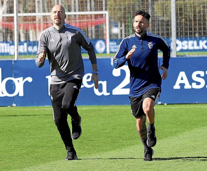 Rubén García, trotando sobre uno de los campos de entrenamiento de Tajonar junto al readaptador físico de Osasuna Diego Chapinal.