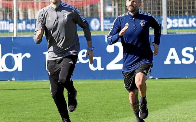 Rubén García, trotando sobre uno de los campos de entrenamiento de Tajonar junto al readaptador físico de Osasuna Diego Chapinal.