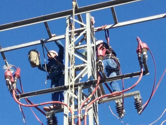 Trabajadores realizando tareas de aislamiento de la torre de media tensión