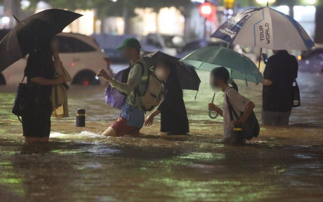 Las fuertes lluvias inundan una calle del sur de Se&uacute;l.