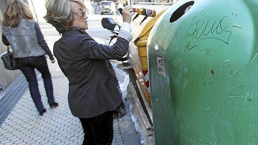 Una mujer recicla unos botellines de vidrio