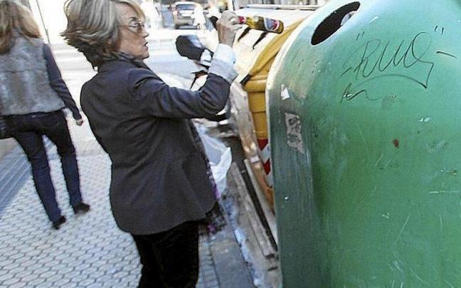 Una mujer recicla unos botellines de vidrio