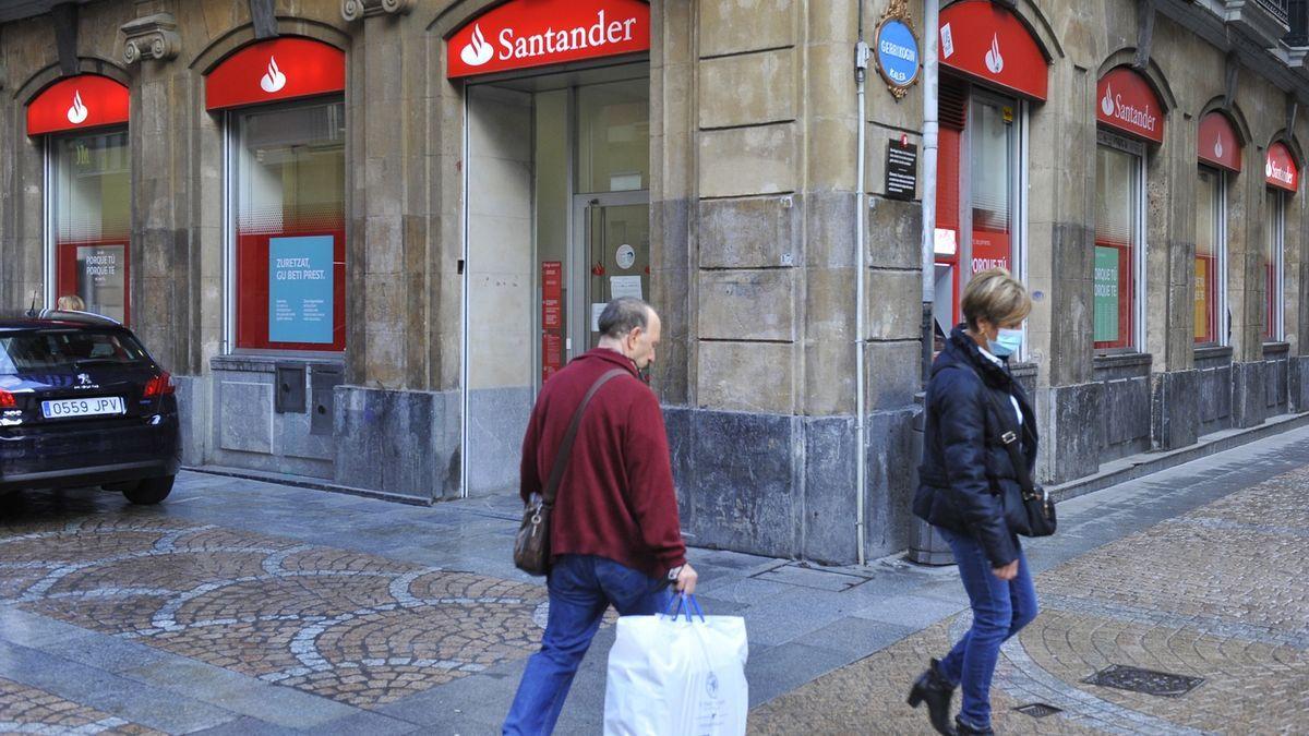 Dos transeúntes pasan frente a una sucursal bancaria en Bilbao.