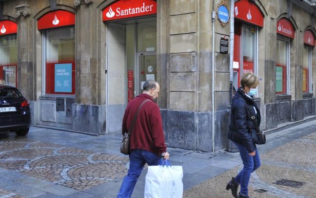 Dos transeúntes pasan frente a una sucursal bancaria en Bilbao. Dos transeúntes pasan frente a una sucursal bancaria en Bilbao.
