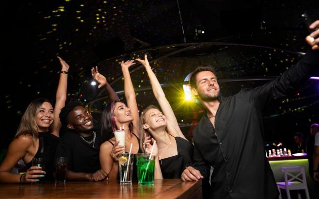 Un grupo de amigos y amigas se hace un selfie en un pub. Un grupo de amigos y amigas se hace un selfie en un pub.