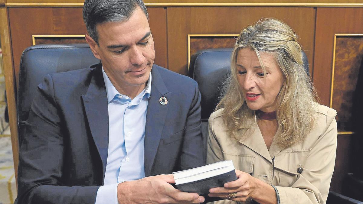 Pedro Sánchez y Yolanda Díaz observan un libro, ayer durante el pleno en el Congreso.