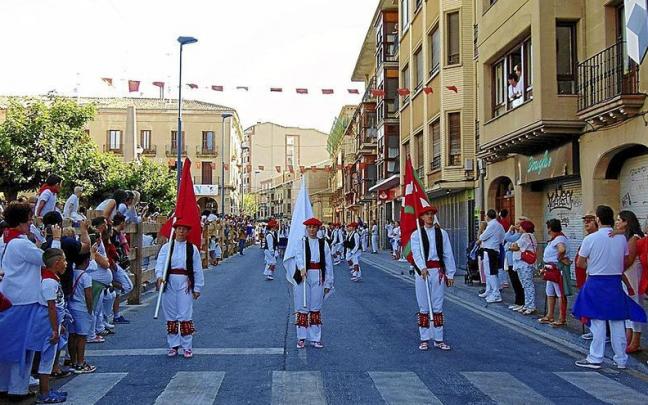 Los vecinos y vecinas de Tafalla observan el desfiles de músicos y dantzaris en honor a Nuestra Señora de la Asunción.