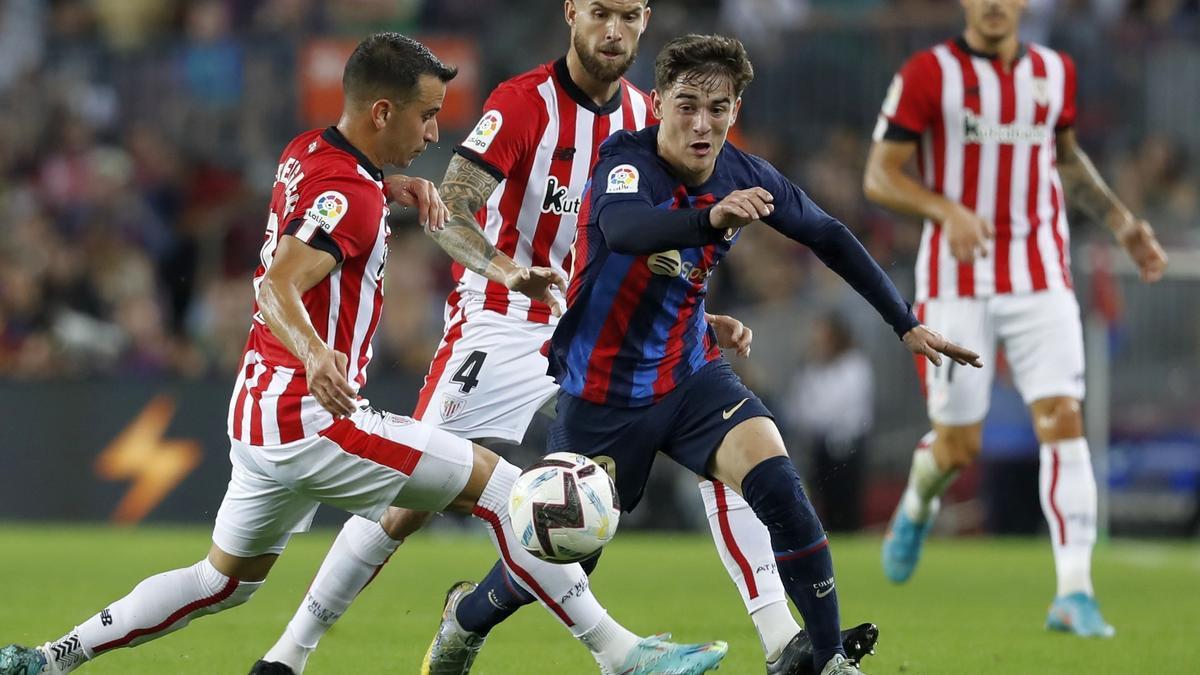 Gavi supera a Berenguer ante la mirada de Iñigo Martínez en un lance del encuentro disputado anoche entre el Barcelona y el Athletic.