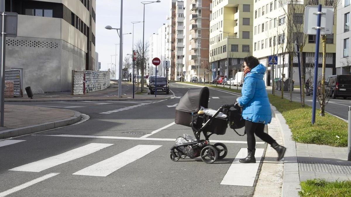 Una mujer, ajena a la información, pasea con un carrito por la Avenida de los Derechos Humanos