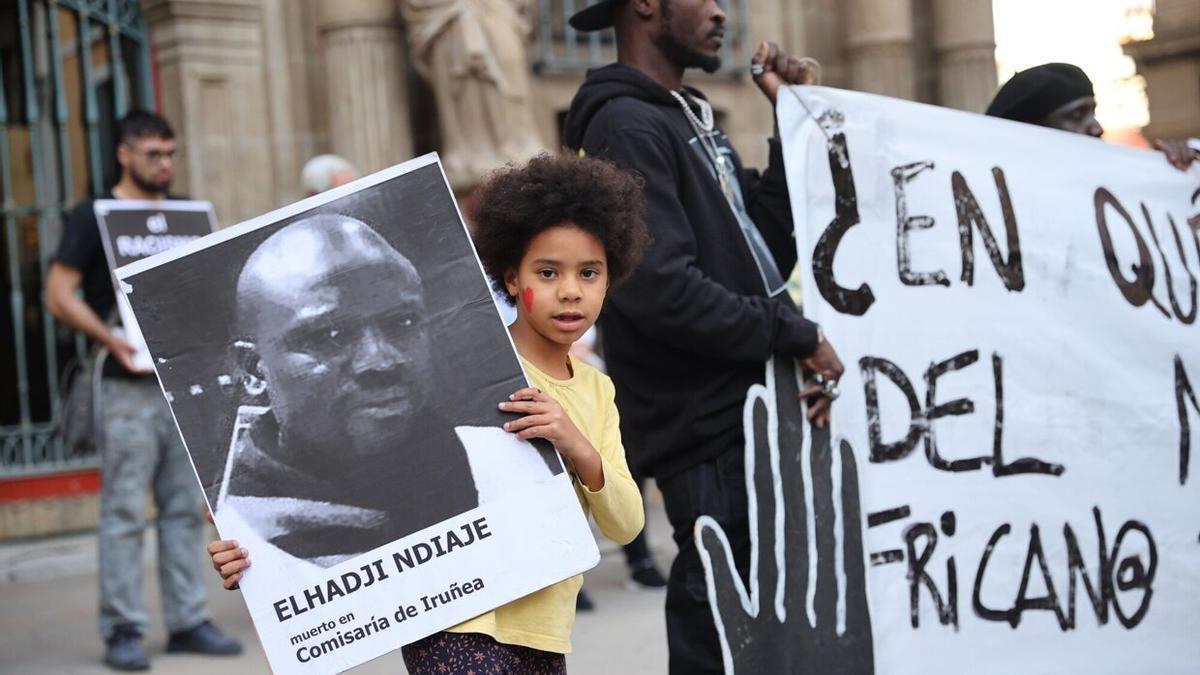 Una niña sujeta la foto de Elhadji Ndiaye en la concentración.