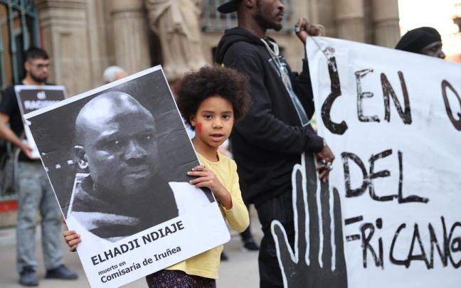 Una niña sujeta la foto de Elhadji Ndiaye en la concentración.