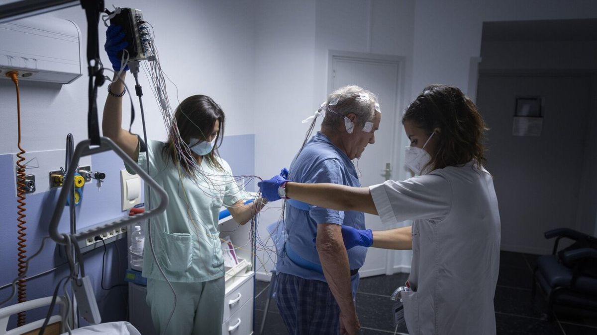 La neurofisióloga Rocío Veredas y la enfermera Irantzu Zahino preparan al paciente Luis Bezunartea para hacerle un estudio de sueño en el HUN.