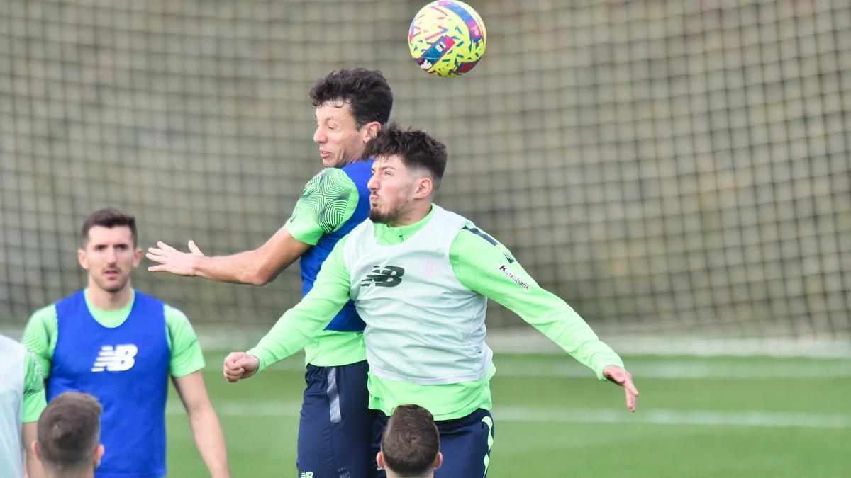 Unai Vencedor salta junto a Mikel Vesga en una disputa de balón durante un entrenamiento en Lezama.