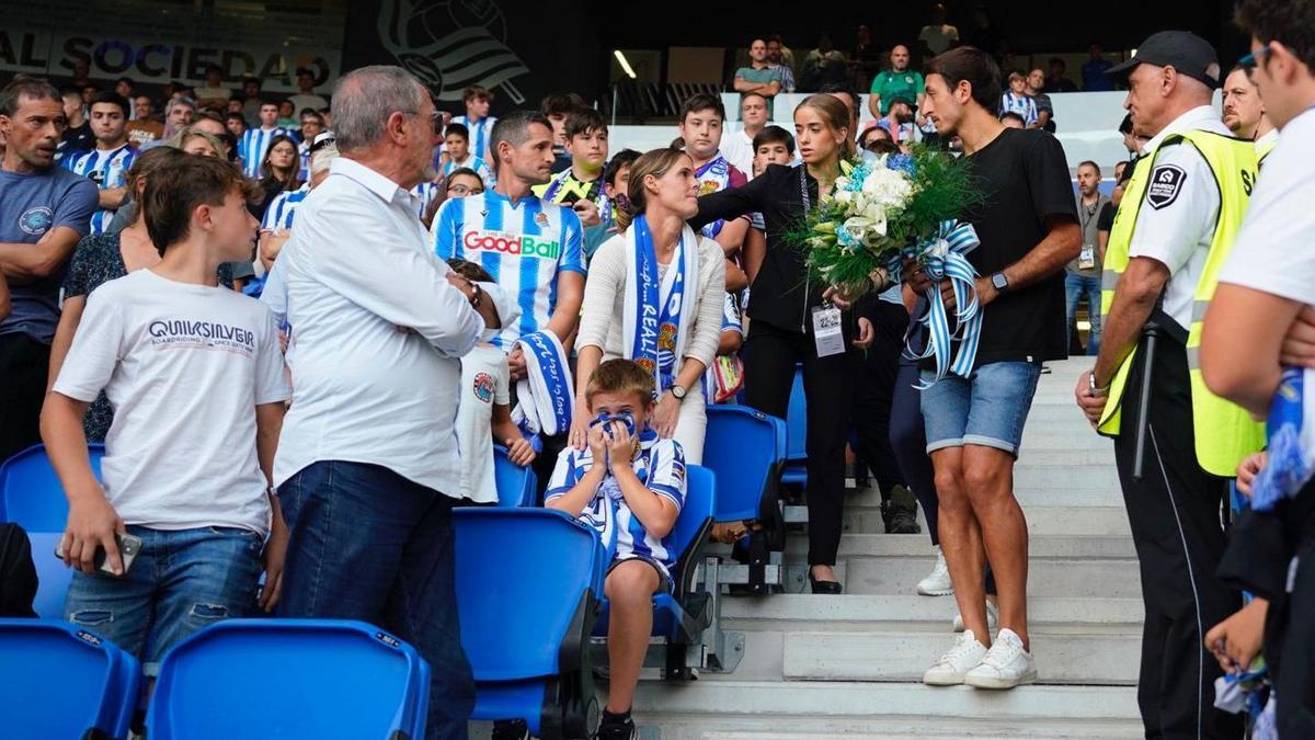 Mikel Oyarzabal se dispone a entregar un ramo de flores a los familiares de Txomin Landa.