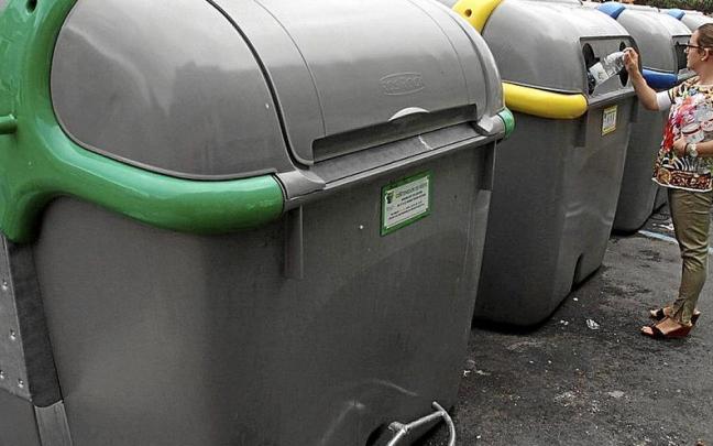 Una vecina de Tudela deposita varias botellas de plástico en el contenedor amarillo de la calle Muro de Tudela.