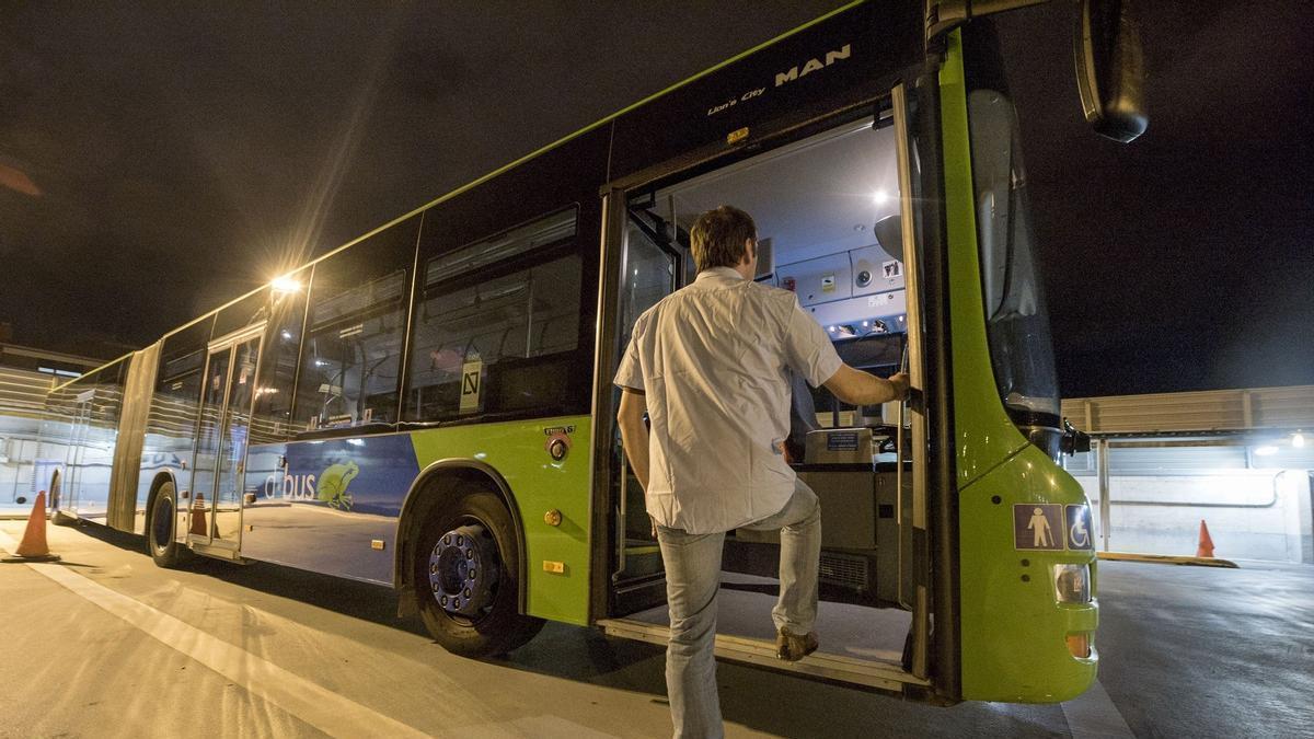 Un chófer sube a un autobús aparcado en Cocheras.