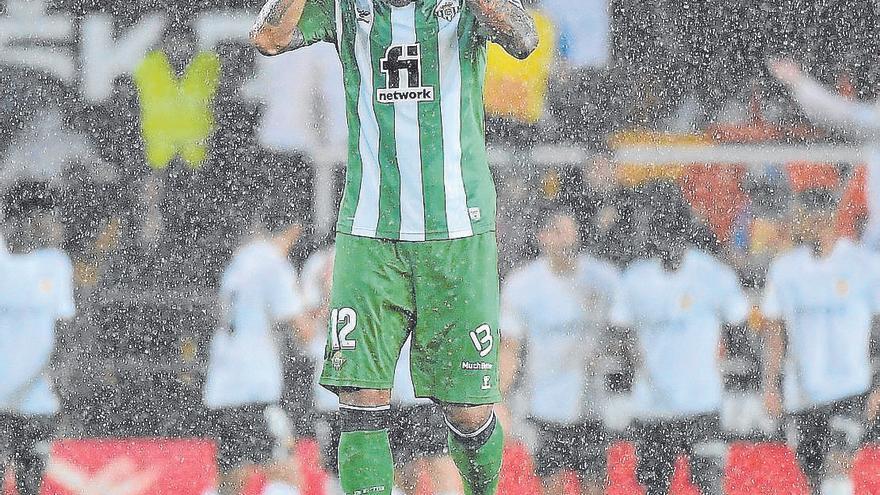 Willian José se lamenta  bajo la lluvia mientras los jugadores de Valencia celebran un gol.