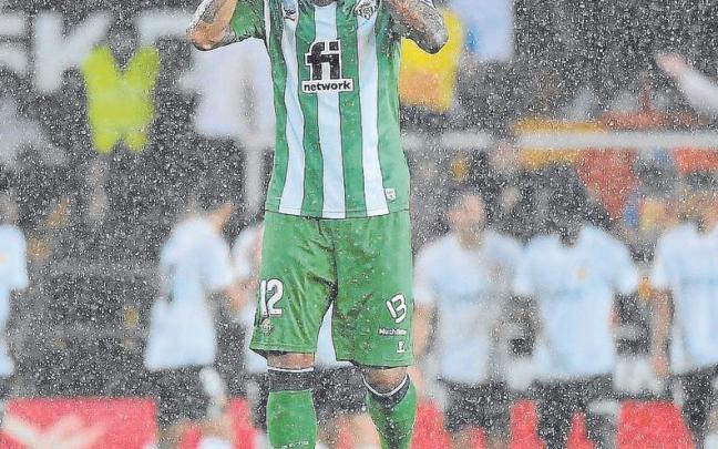 Willian José se lamenta  bajo la lluvia mientras los jugadores de Valencia celebran un gol.