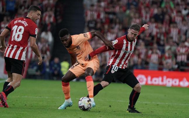 Iker Muniain pugna por un bal&oacute;n con Lemar.