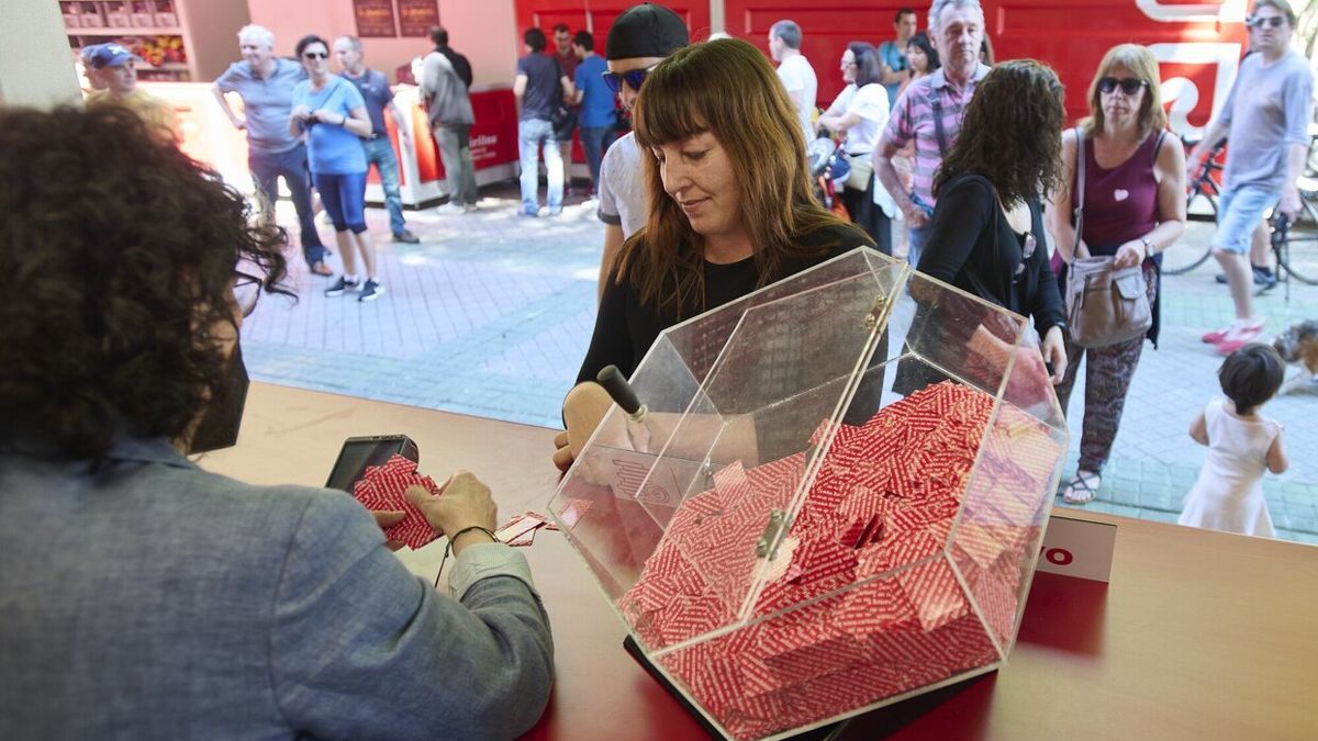 Una mujer compra boletos de la T&oacute;mbola en el paseo de Sarasate.