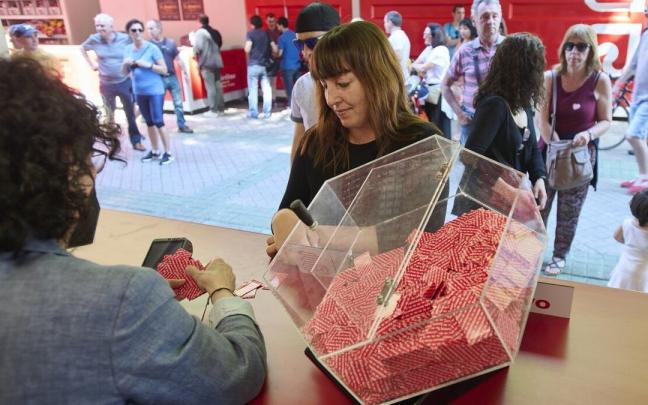 Una mujer compra boletos de la T&oacute;mbola en el paseo de Sarasate.