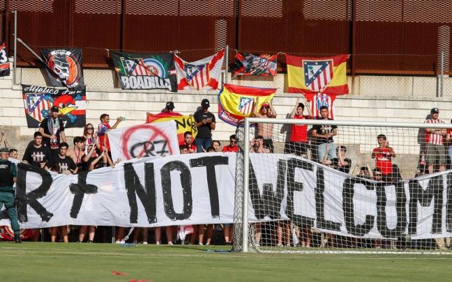 Aficionados del Atlético de Madrid portan una pancarta contra Cristiano Ronaldo en un amistoso contra el Numancia