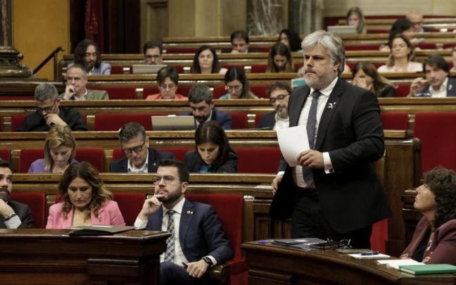 Albert Batet, de Junts, pasa junto a Pere Aragonès en la última sesión en el Parlament