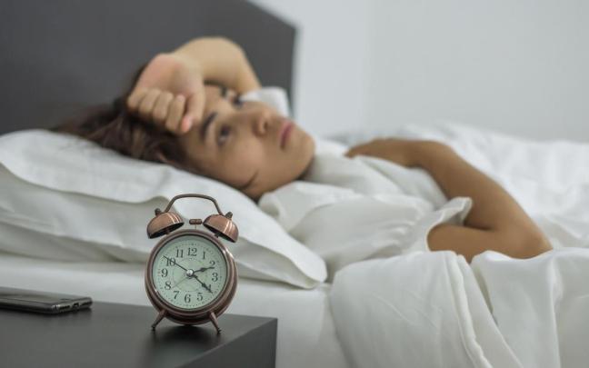 Una mujer ve pasar las horas sin poder conciliar el sueño. Una mujer ve pasar las horas sin poder conciliar el sueño.