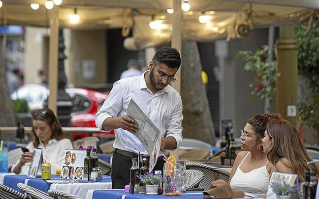 Un camarero atiende una mesa en una terraza. | FOTO: E.P. Un camarero atiende una mesa en una terraza. | FOTO: E.P.
