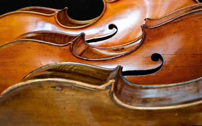 Imagen de detalle de unos violonchelos