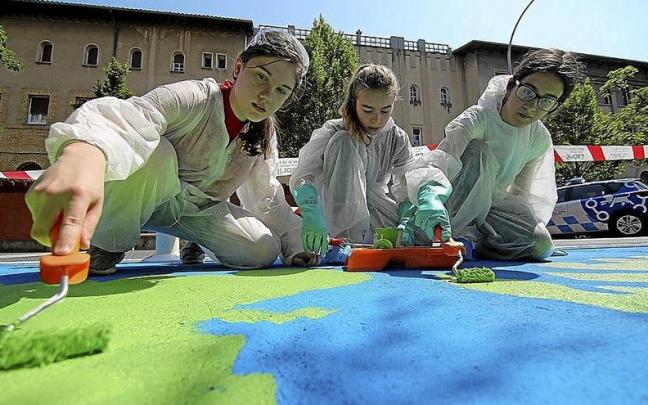 Alumnas del colegio Sagrado Coraz&oacute;n pintan la calzada.