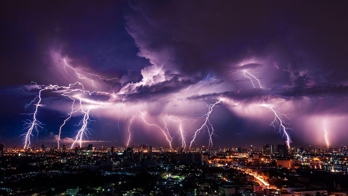 Diferentes rayos provocados por una tormenta eléctrica caen sobre una ciudad.